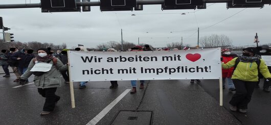 Pflegerinnen mit Transparent.