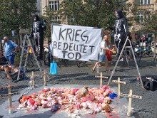 Zwei Teilnehmer als Tod verkleidet. Auf dem Boden sind gestellte Baby-Leichen. Friedensdemo. Frankfurt am Main, 29.06.24